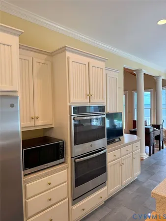 a kitchen with white cabinets and stainless steel appliances