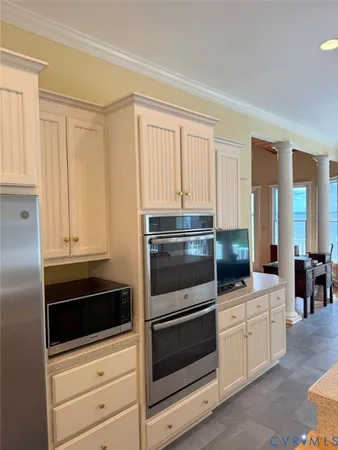 a kitchen with white cabinets and stainless steel appliances