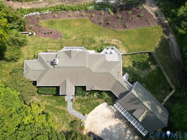 an aerial view of a house with a garden and lake view