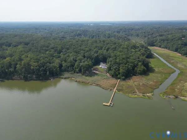 an aerial view of a house with a yard and lake view