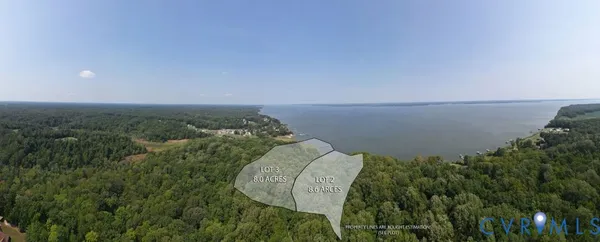 an aerial view of a house with a yard and lake view