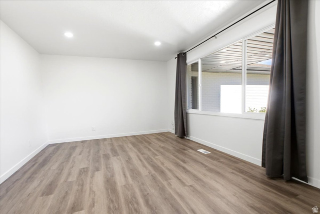 1676 East 11245 South Sandy, UT 84092 - Photo 11 of 34 Bright interior space featuring wood-finish flooring, recessed lighting, and a large multi-pane window