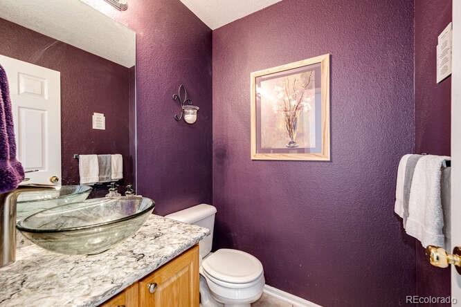 10143 Astorbrook Lane Highlands Ranch, CO 80126 - Photo 12 of 39 a bathroom with a granite countertop toilet sink and mirror