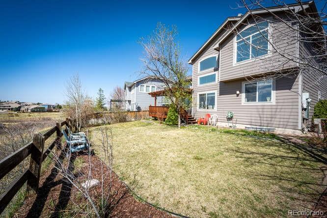 10143 Astorbrook Lane Highlands Ranch, CO 80126 - Photo 31 of 39 a backyard of a house with table and chairs