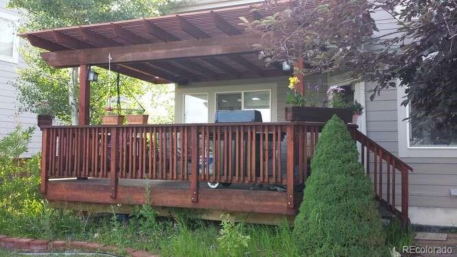 10143 Astorbrook Lane Highlands Ranch, CO 80126 - Photo 36 of 39 a view of a backyard with table and chairs under an umbrella with wooden fence