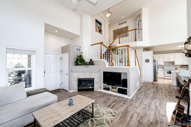 10143 Astorbrook Lane Highlands Ranch, CO 80126 - Photo 6 of 39 a living room with furniture a flat screen tv and a fireplace