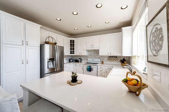 10143 Astorbrook Lane Highlands Ranch, CO 80126 - Photo 9 of 39 a kitchen with sink refrigerator and stove