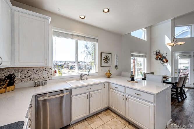 10143 Astorbrook Lane Highlands Ranch, CO 80126 - Photo 10 of 39 a kitchen with a sink window and cabinets