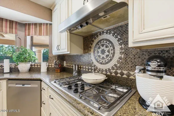 a kitchen with granite countertop a sink and white cabinets