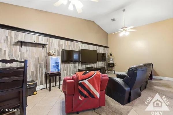 a living room with furniture a flat screen tv and kitchen view