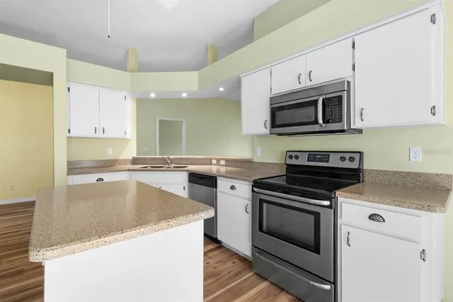 a kitchen with stainless steel appliances granite countertop a stove microwave and sink
