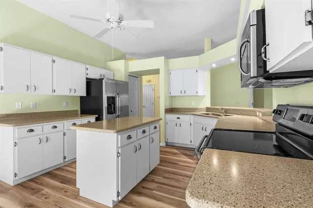 a kitchen with stainless steel appliances a stove a sink cabinets and a refrigerator
