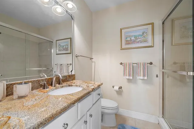 a bathroom with a granite countertop sink toilet and shower
