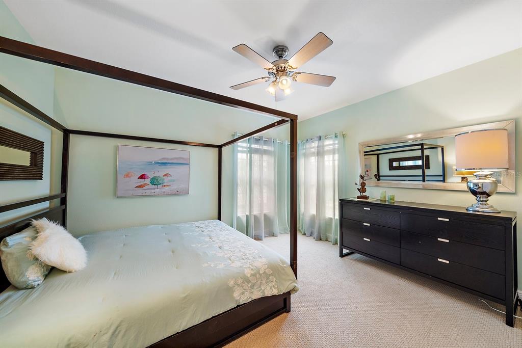 8406 Miramar Way, Unit 8406 Lakewood Ranch, FL 34202 - Photo 22 of 31 a bedroom with a bed and a chandelier