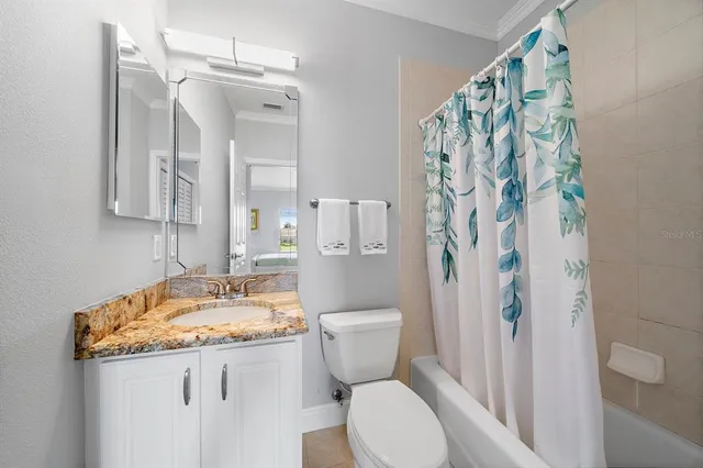 a bathroom with a granite countertop toilet a sink and a shower