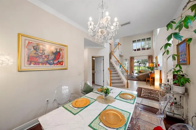 a view of a dining room with furniture a chandelier and wooden floor