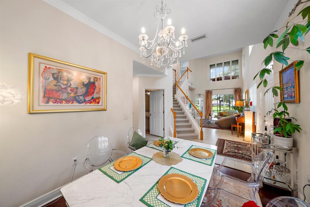 8406 Miramar Way, Unit 8406 Lakewood Ranch, FL 34202 - Photo 7 of 31 a view of a dining room with furniture a chandelier and wooden floor