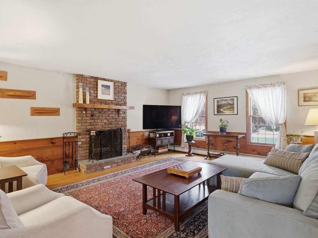 10 Berkeley Lane Andover, MA 01810 - Photo 12 of 42 a living room with furniture a flat screen tv and a fireplace