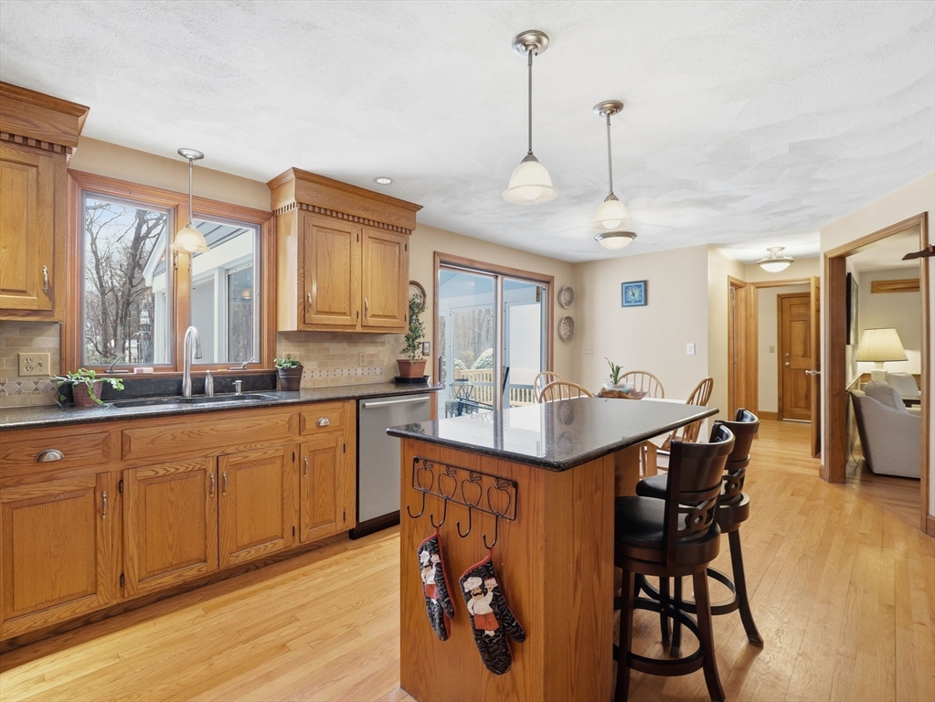 10 Berkeley Lane Andover, MA 01810 - Photo 9 of 42 a kitchen with stainless steel appliances granite countertop a sink a stove a dining table and chairs