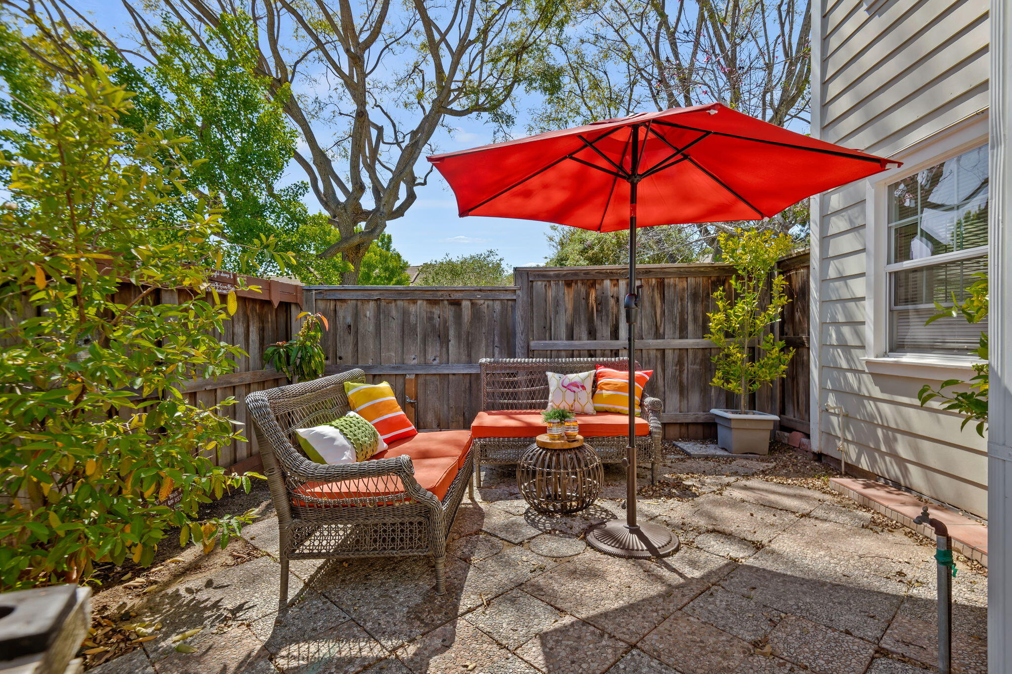 an outdoor sitting area with chairs and table in the patio