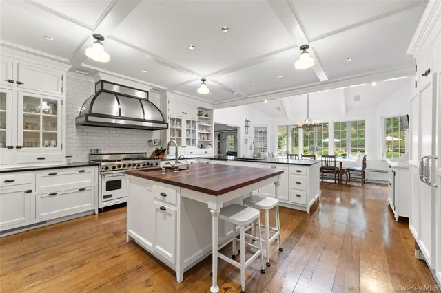 a kitchen with stainless steel appliances granite countertop a stove top oven a sink and a refrigerator