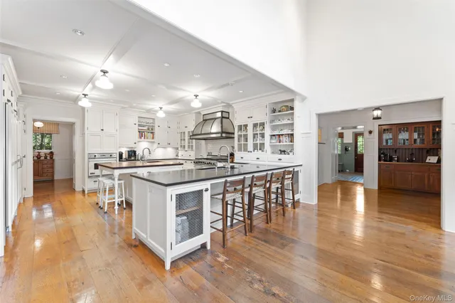 a view of a dining room and livingroom with furniture wooden floor a chandelier