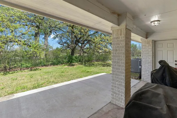 a view of backyard with large trees and a small yard