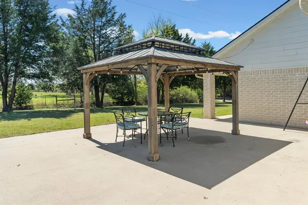 a view of a porch with chairs and backyard