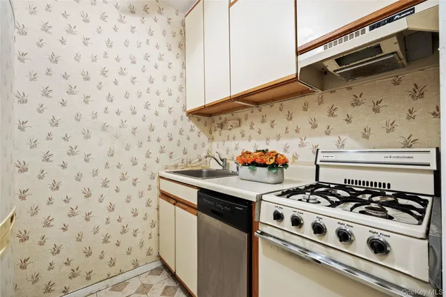 a white stove top oven sitting inside of a kitchen