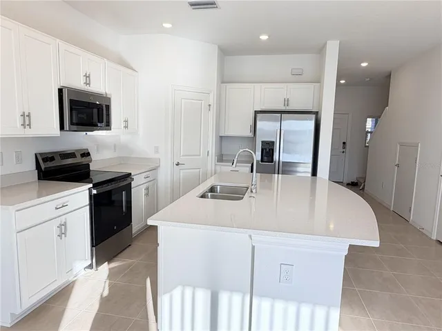 a kitchen with kitchen island a sink stainless steel appliances and cabinets