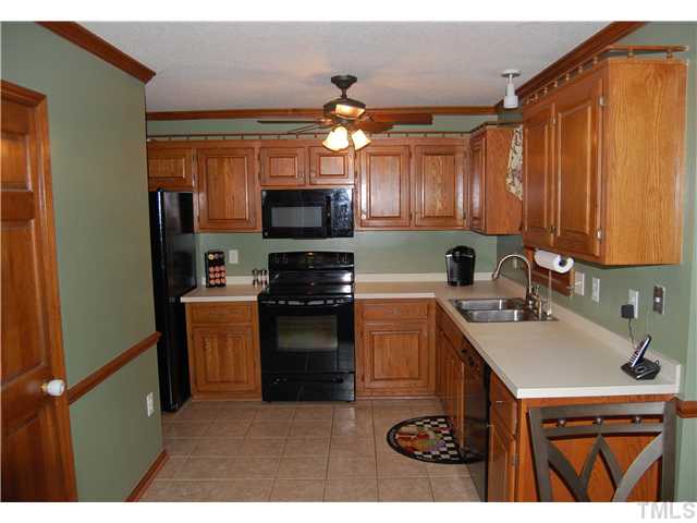 608 South Meadow Road Raleigh, NC 27603 - Photo 10 of 25 a kitchen with a sink a stove cabinets and a refrigerator