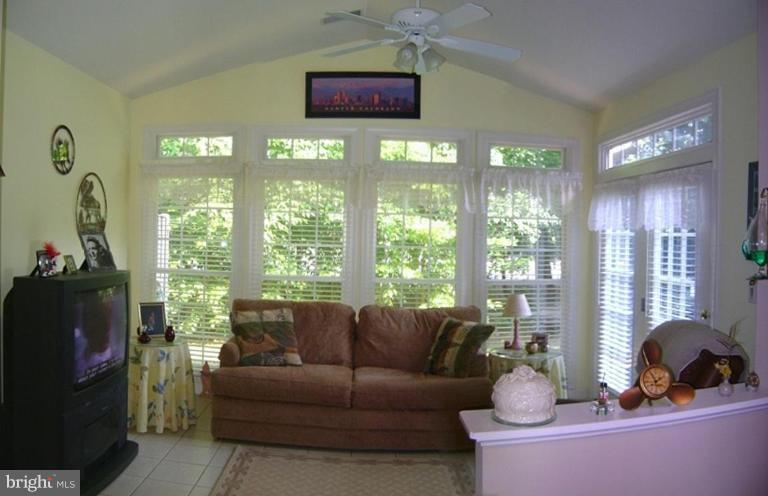 375 Colony Point Place Edgewater, MD 21037 - Photo 3 of 18 a living room with furniture a flat screen tv and a floor to ceiling window