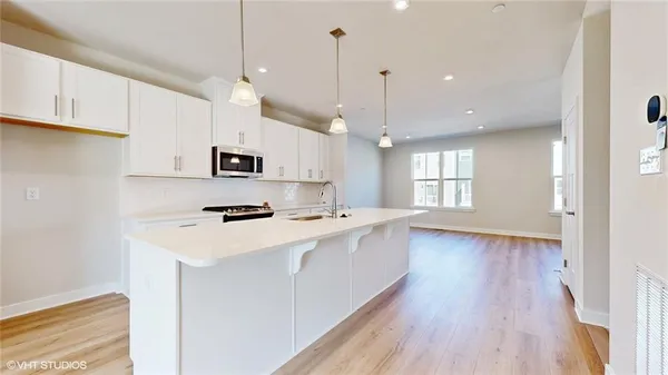 a kitchen with a sink a stove and a microwave