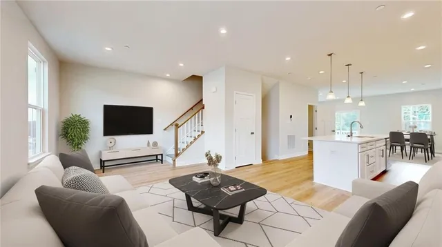 a view of a dining room and livingroom with furniture wooden floor a rug a potted plant and a chandelier