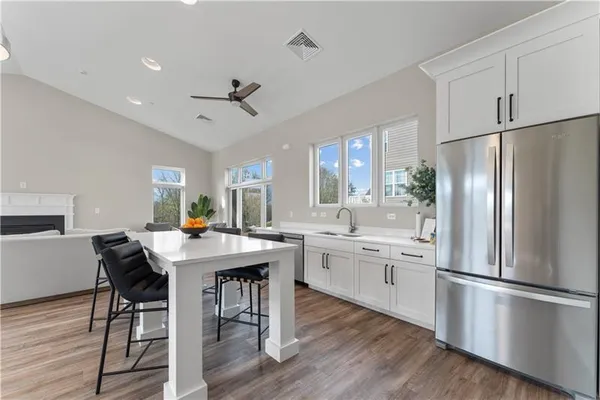 a living room with lots of furniture and view of kitchen