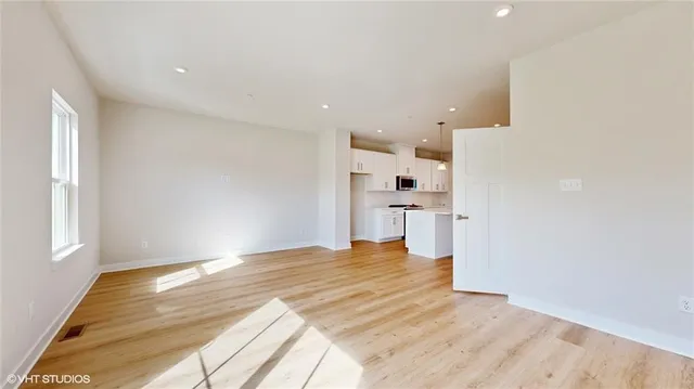 a view of empty room with wooden floor