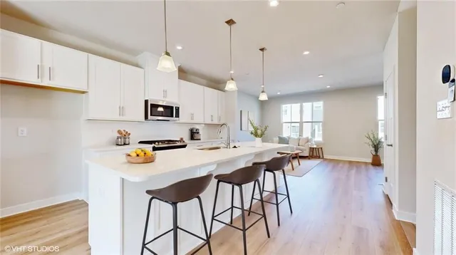 a kitchen with stainless steel appliances a table chairs refrigerator and microwave