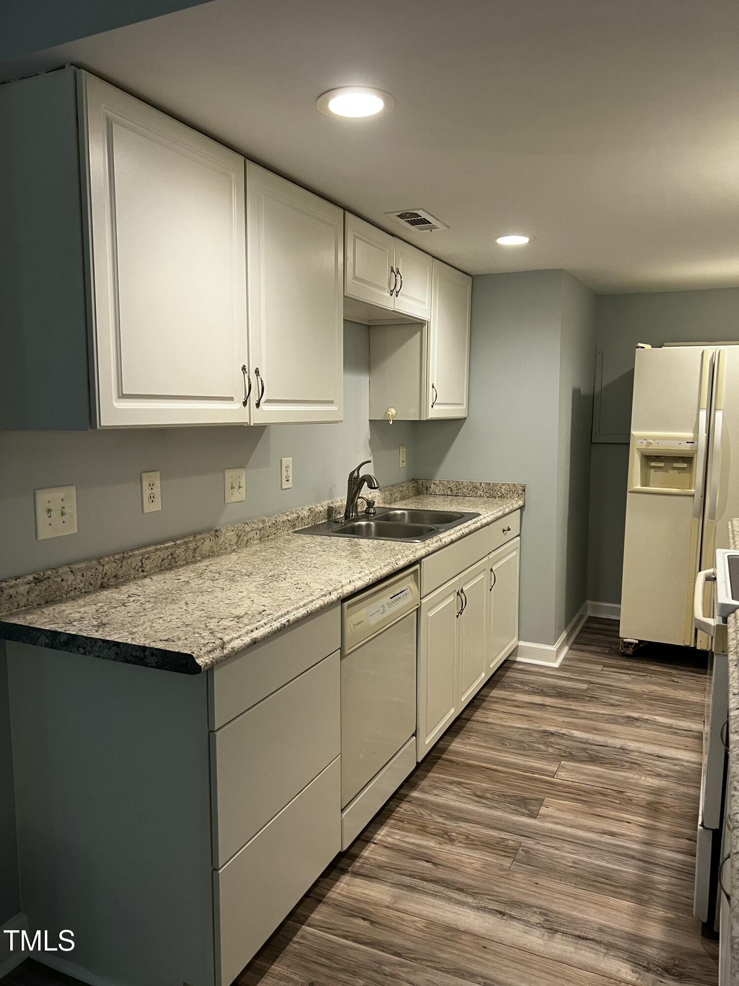 4519 Edwards Mill Road, Unit J Raleigh, NC 27612 - Photo 7 of 20 a kitchen with a sink stove and cabinets