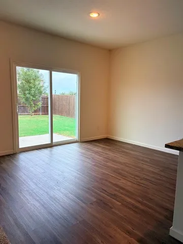 a view of a room with wooden floor and window