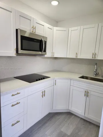 a kitchen with white cabinets and white appliances