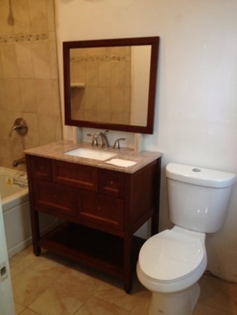 200 Brooks Street, Unit 1 Boston, MA 02128 - Photo 9 of 10 a bathroom with a toilet sink and mirror
