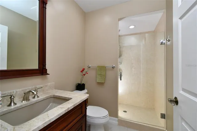 a bathroom with a granite countertop sink toilet and shower