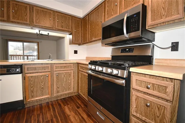 a kitchen with stainless steel appliances a stove a microwave and cabinets