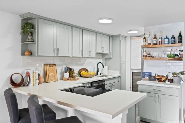 a kitchen with a sink a stove and white cabinets