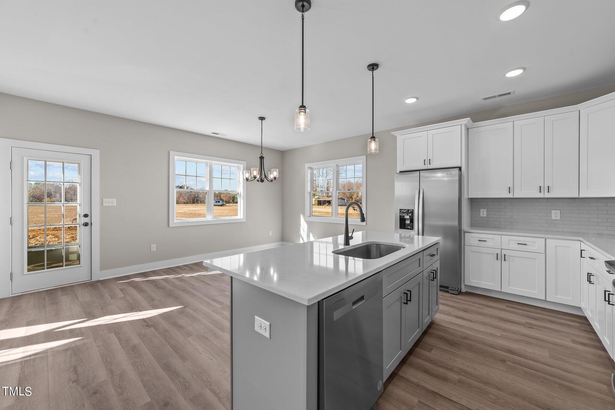 6041 Farmwood Loop Wilson, NC 27896 - Photo 11 of 38 a kitchen with stainless steel appliances granite countertop a sink stove and refrigerator