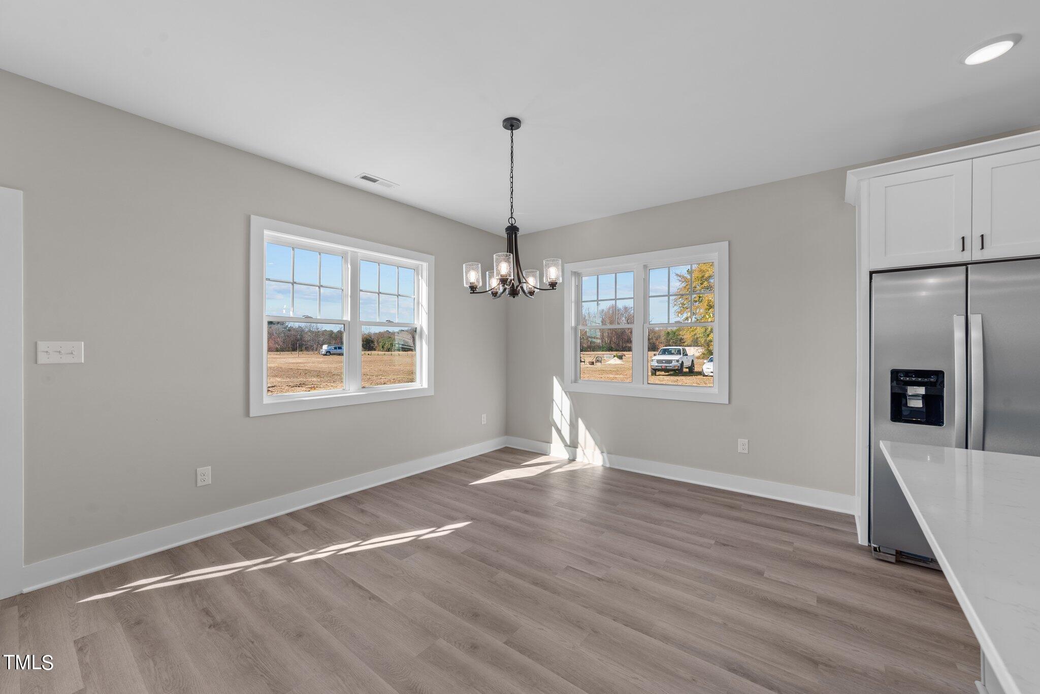 6041 Farmwood Loop Wilson, NC 27896 - Photo 15 of 38 a view of an empty room with window and wooden floor
