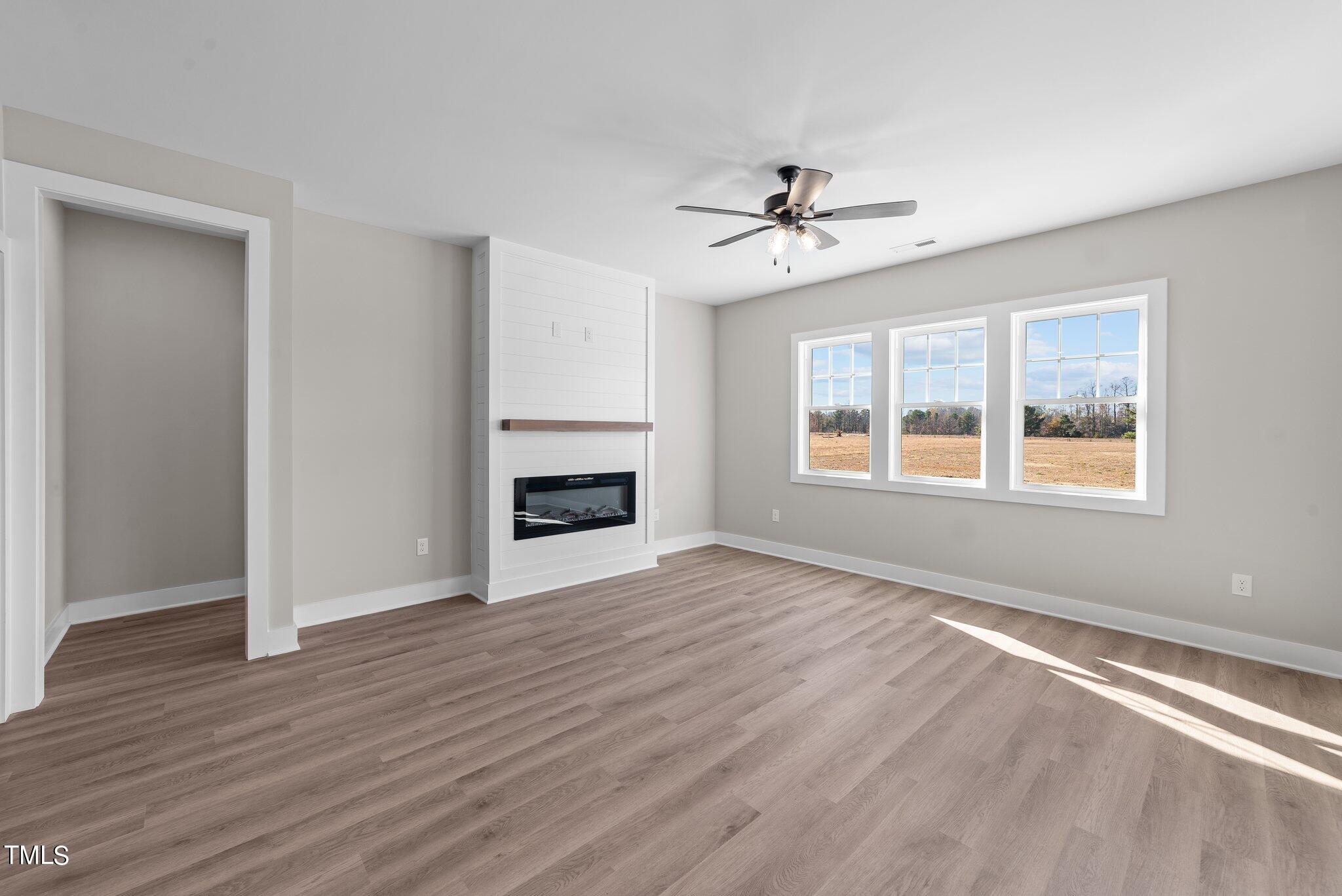 6041 Farmwood Loop Wilson, NC 27896 - Photo 5 of 38 a view of an empty room with a window and wooden floor