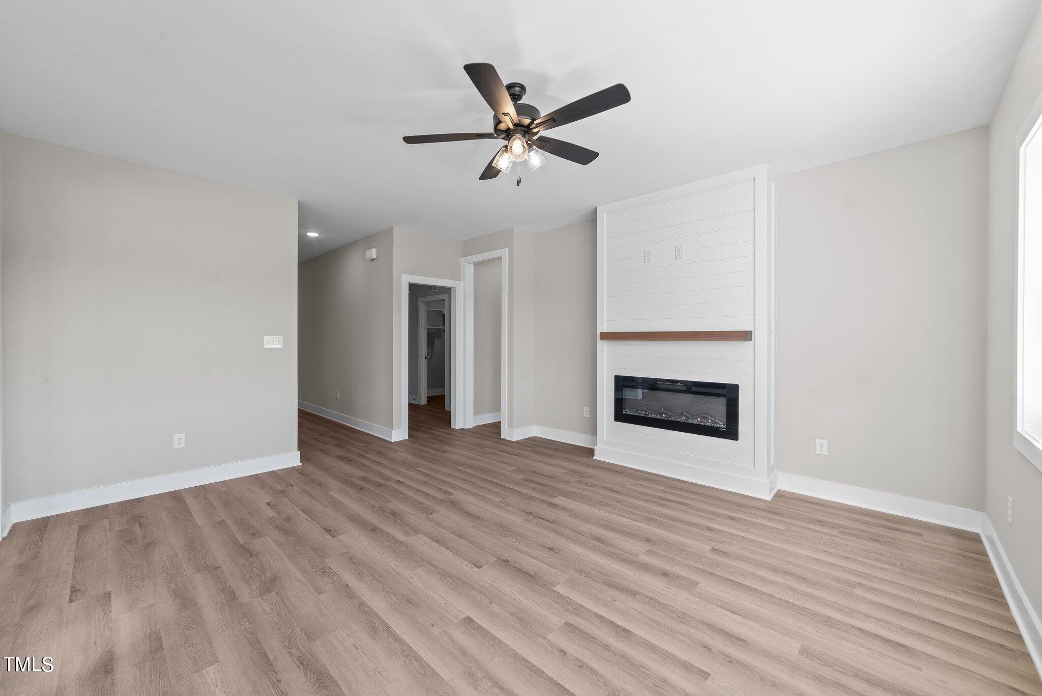 6041 Farmwood Loop Wilson, NC 27896 - Photo 8 of 38 a view of an empty room with wooden floor and a ceiling fan