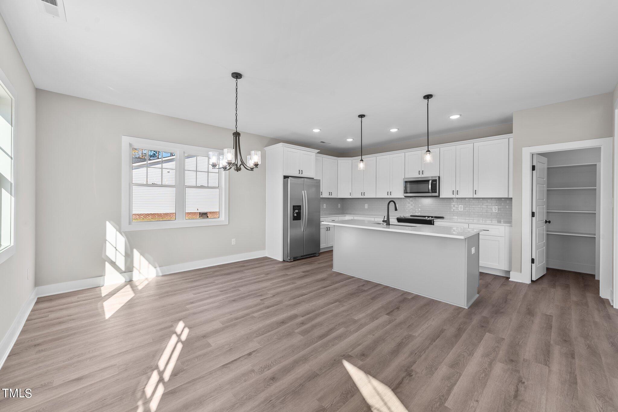 6041 Farmwood Loop Wilson, NC 27896 - Photo 9 of 38 a kitchen with a refrigerator and white cabinets