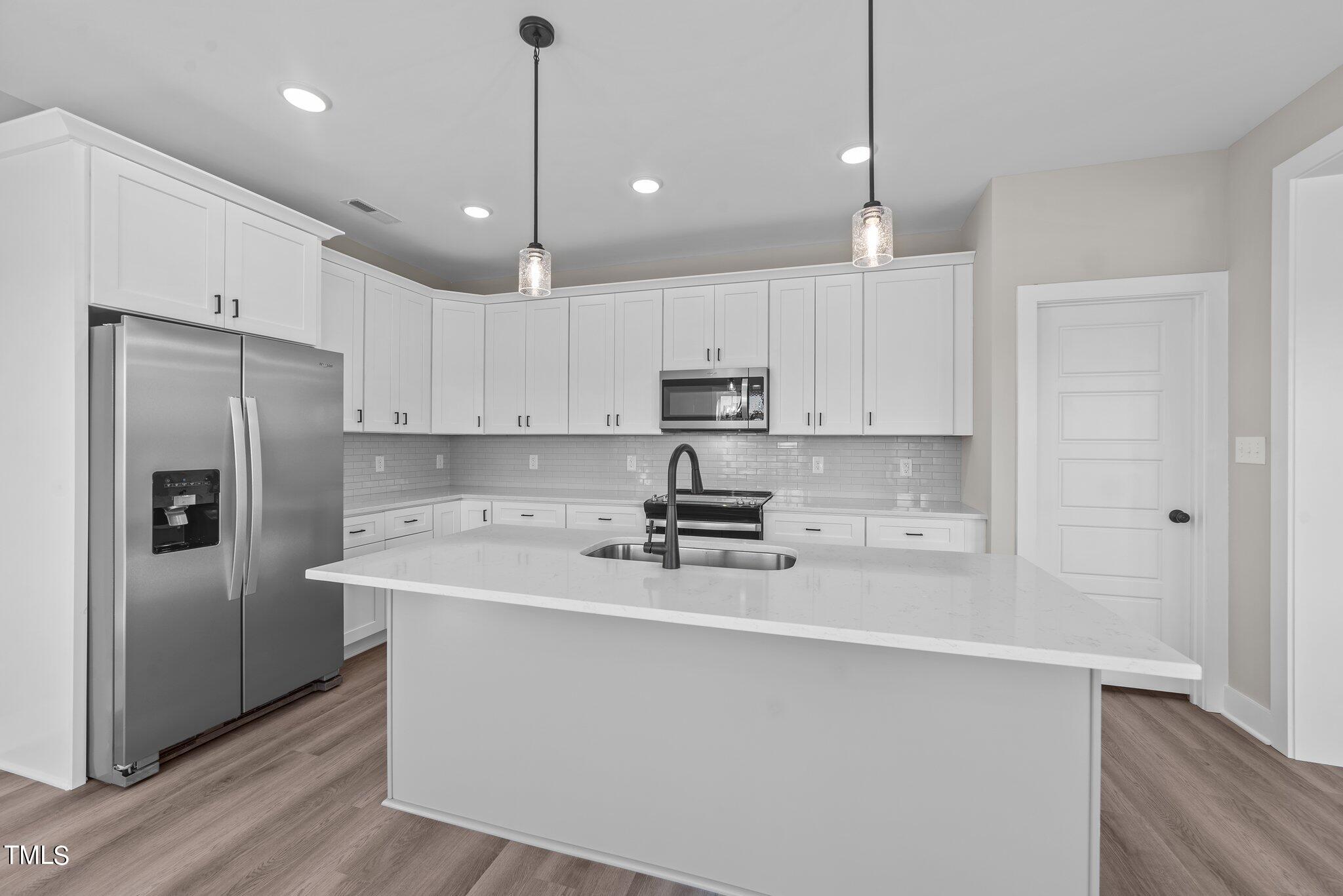 6041 Farmwood Loop Wilson, NC 27896 - Photo 10 of 38 a kitchen with kitchen island a white counter top space cabinets and stainless steel appliances